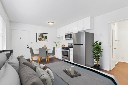 a living room with a couch a table and a refrigerator