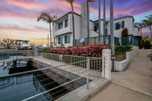 a house overlooking a body of water with a sunset in the background