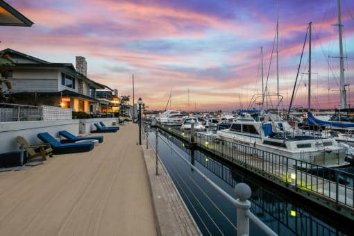 a marina at sunset with boats in the water and a house on the side of the
