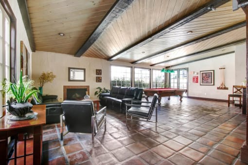 a large living room with a pool table in the corner