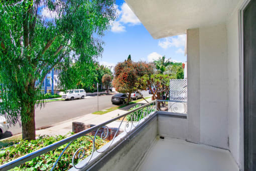 a balcony with a tree and a street in the background