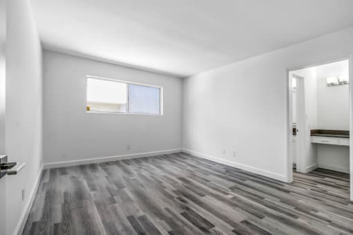 a bedroom with hardwood floors and grey walls