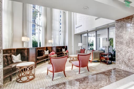 a lobby with chairs and couches and large windows