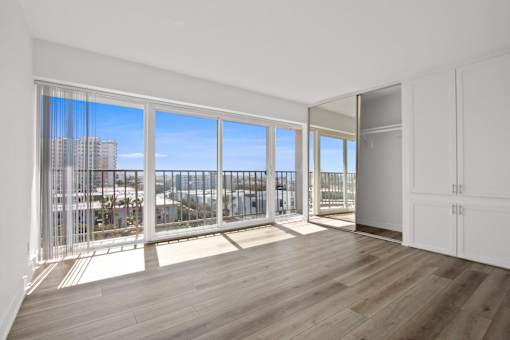 A room with a view of the city through large windows.