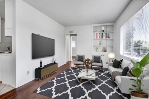 a living room with a couch coffee table and a tv on the wall