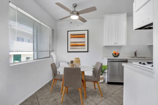 a dining area with a table and chairs and a ceiling fan