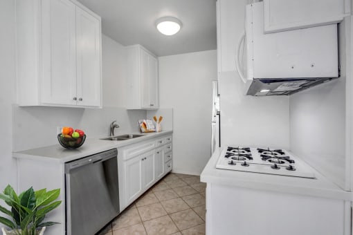 a kitchen with white cabinetry and a white stove top oven