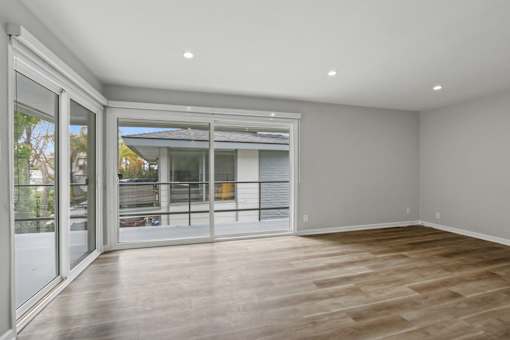 A room with a sliding glass door leading to a balcony.