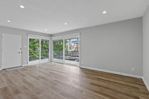 A room with a white door and a balcony with a table and chairs.