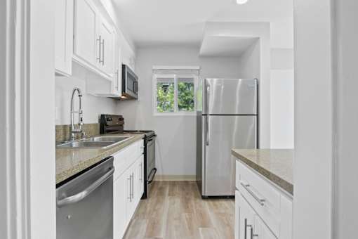 A modern kitchen with stainless steel appliances and white cabinets.