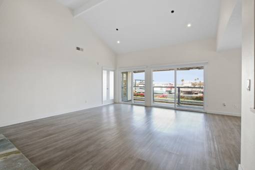 A large empty room with wooden floors and white walls.