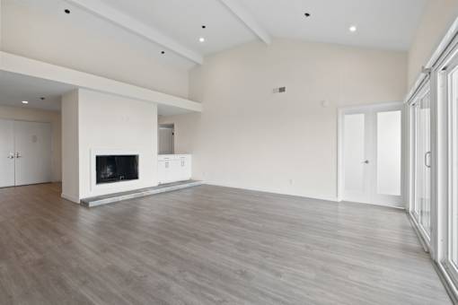 A spacious living room with a fireplace and hardwood flooring.