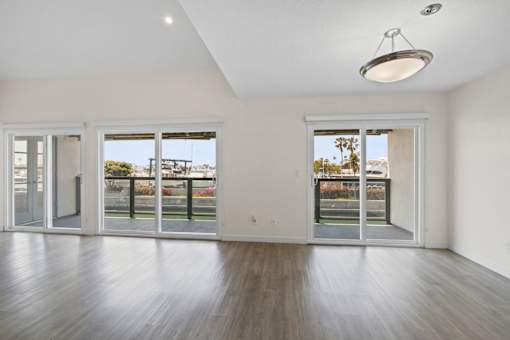 A spacious room with wooden floors and sliding glass doors.