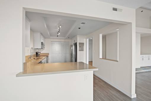 A kitchen with white cabinets and a wooden countertop.