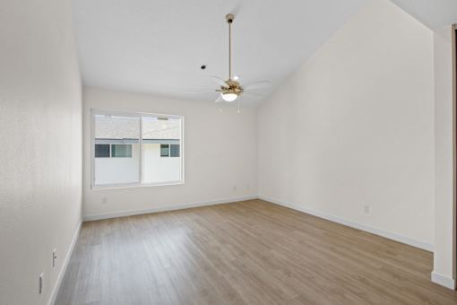 A room with a ceiling fan and a window.