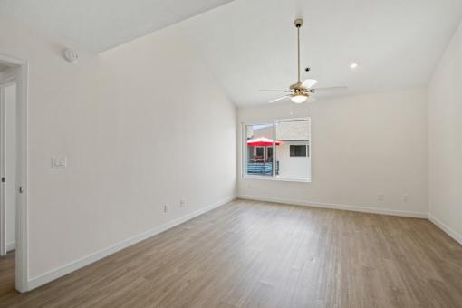 Empty room with a ceiling fan and a window.
