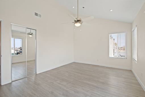A spacious room with a ceiling fan and sliding glass doors.