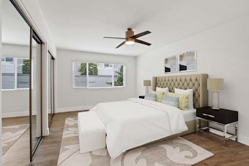 A bedroom with a large bed and a ceiling fan.