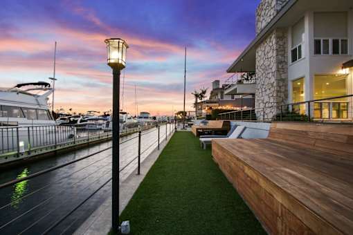 A wooden lamp post stands on a grassy area next to a building.