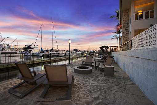 A sandy beach area with chairs and a table.