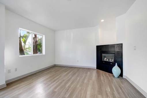 A room with a fireplace and a vase on the floor.