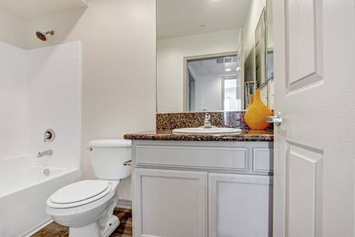 A white toilet sits next to a bathtub in a bathroom.