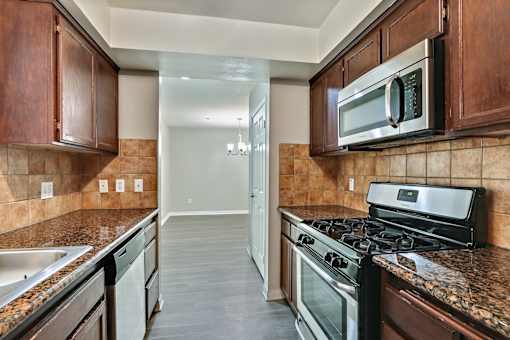 A kitchen with a black stove top oven and a black microwave above it.