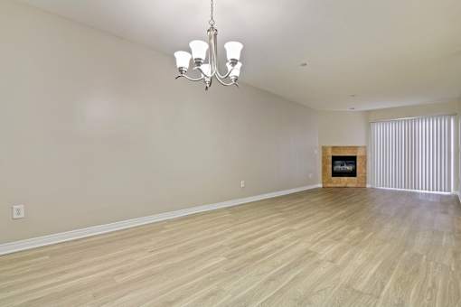 A room with wooden flooring and a chandelier.
