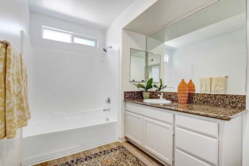 A bathroom with a white tub and sink.