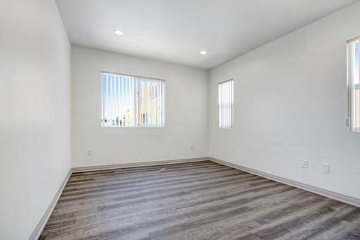 A room with a large window and wooden flooring.