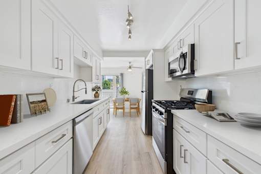 A kitchen with white cabinets and a black stove top oven.