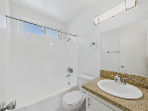 A white bathroom with a toilet, sink, and tub.