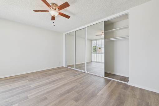 A room with a ceiling fan and a sliding door.