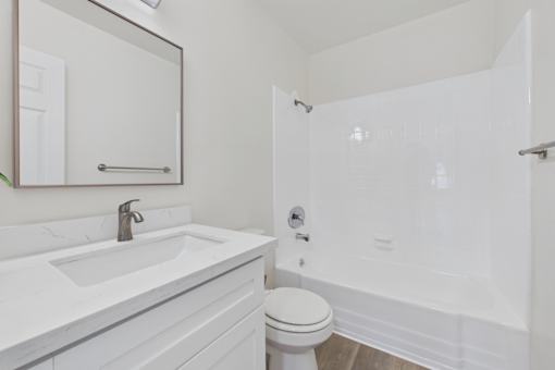 A white bathroom with a sink, toilet, and bathtub.