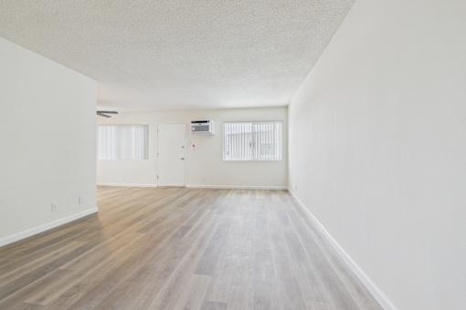 A room with wooden flooring and white walls.