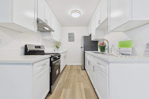 A kitchen with white cabinets and appliances.