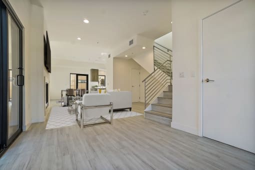 a living room with a couch and a table and a staircase