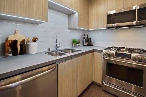 a modern kitchen with stainless steel appliances and wooden cabinets