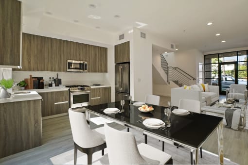 a large kitchen and dining room with a black table and chairs