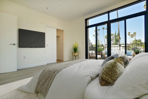 a bedroom with a large bed and a tv on the wall