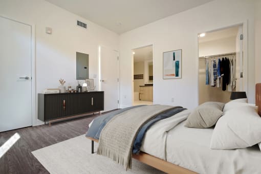 a bedroom with a large bed and a closet and a bathroom
