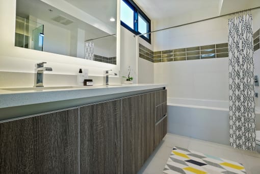 a bathroom with a long counter and a large mirror