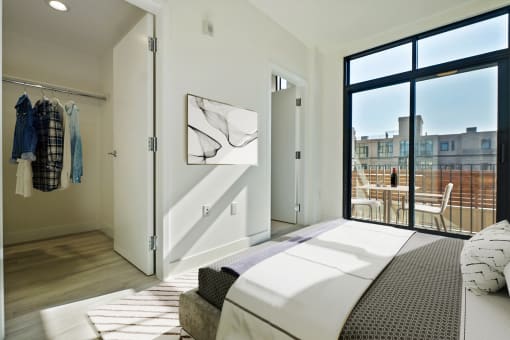 a bedroom with a bed and a door to a balcony