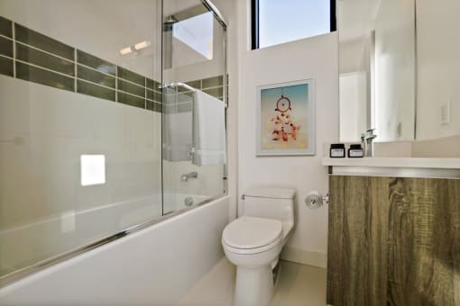 a white bathroom with a toilet and a shower