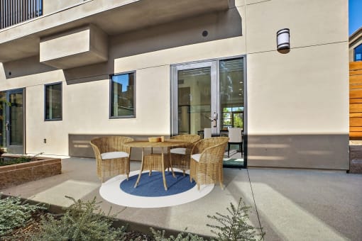 a patio with a table and chairs in front of a house