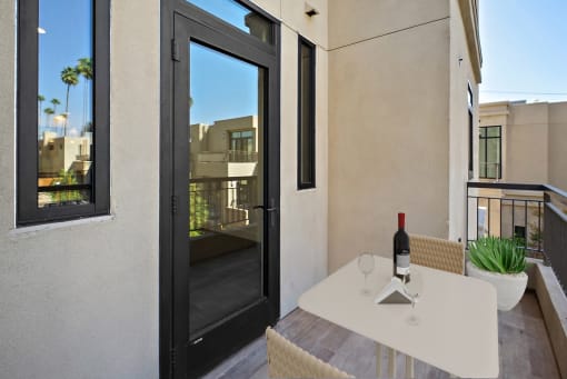 a patio with a table and a bottle of wine on it