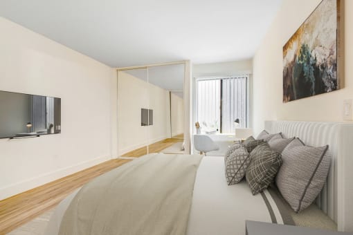 the master bedroom has a large bed and a tv in the corner