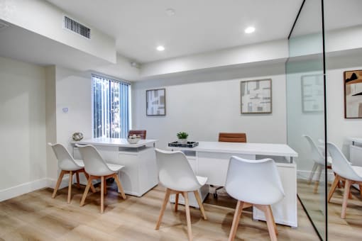 a white office with a white desk and chairs
