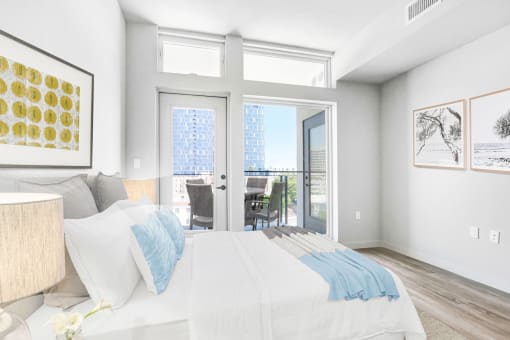 a bedroom with a bed and sliding glass doors to a balcony