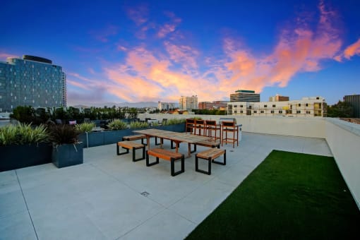 a seating area on the roof of a building at sunset